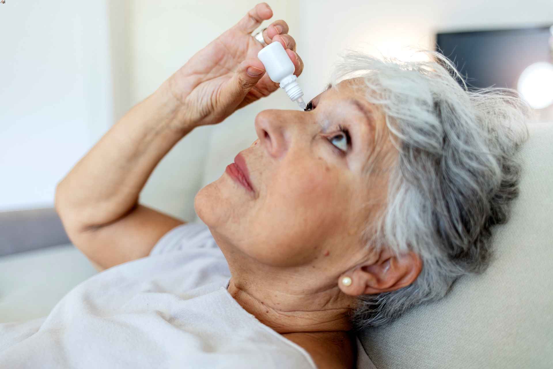 A person using eye drops